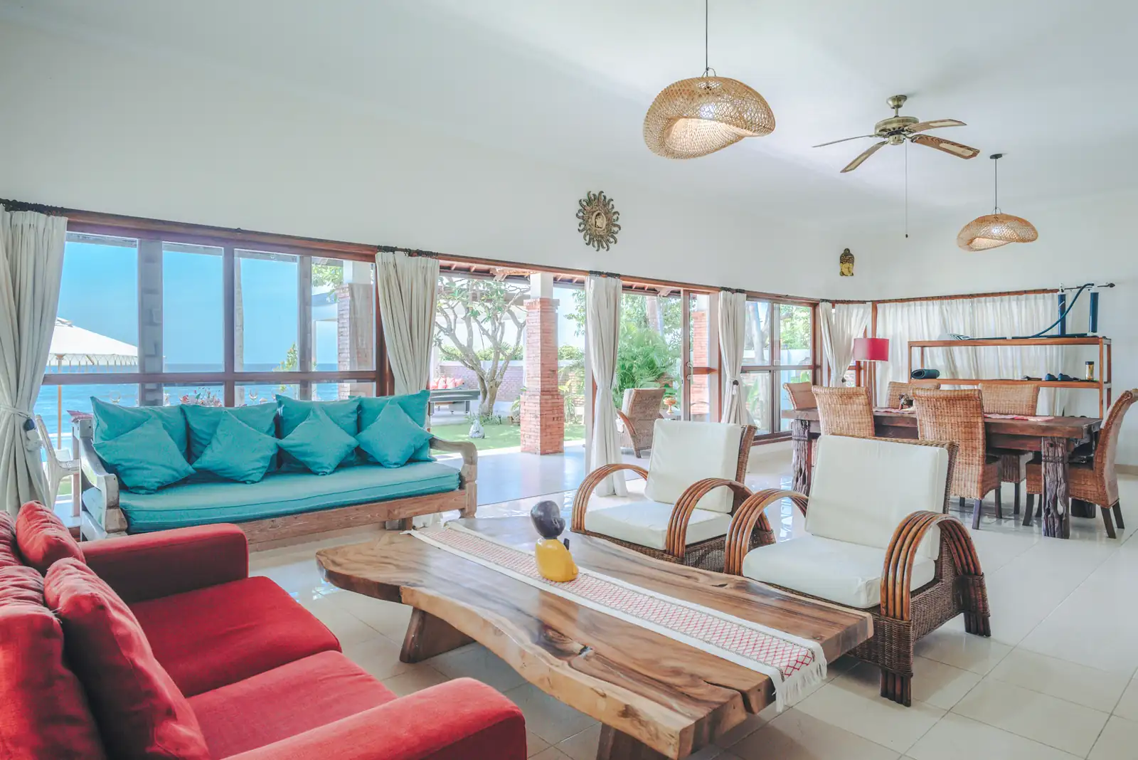 Wide view of living and dining area at Primavera Beach House with sea visible through the windows.